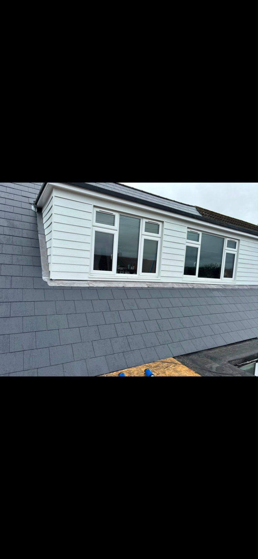 Slate re-roof to a pitched roof with dormer cladding and leadwork, scaffolding still up