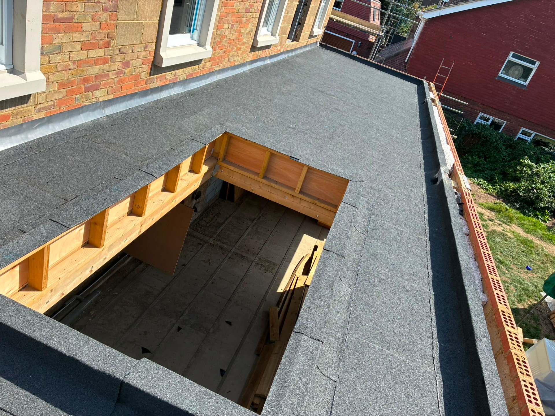 Flat roof with mineral felt and lead flashing, with an opening framed for a rooflight