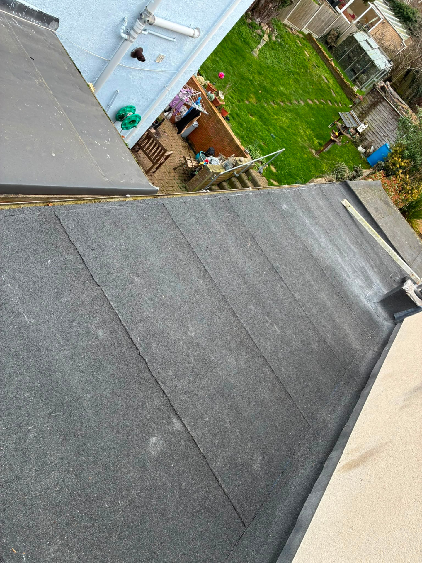 Finished mineral felt flat roof with lead flashing where it meets the wall