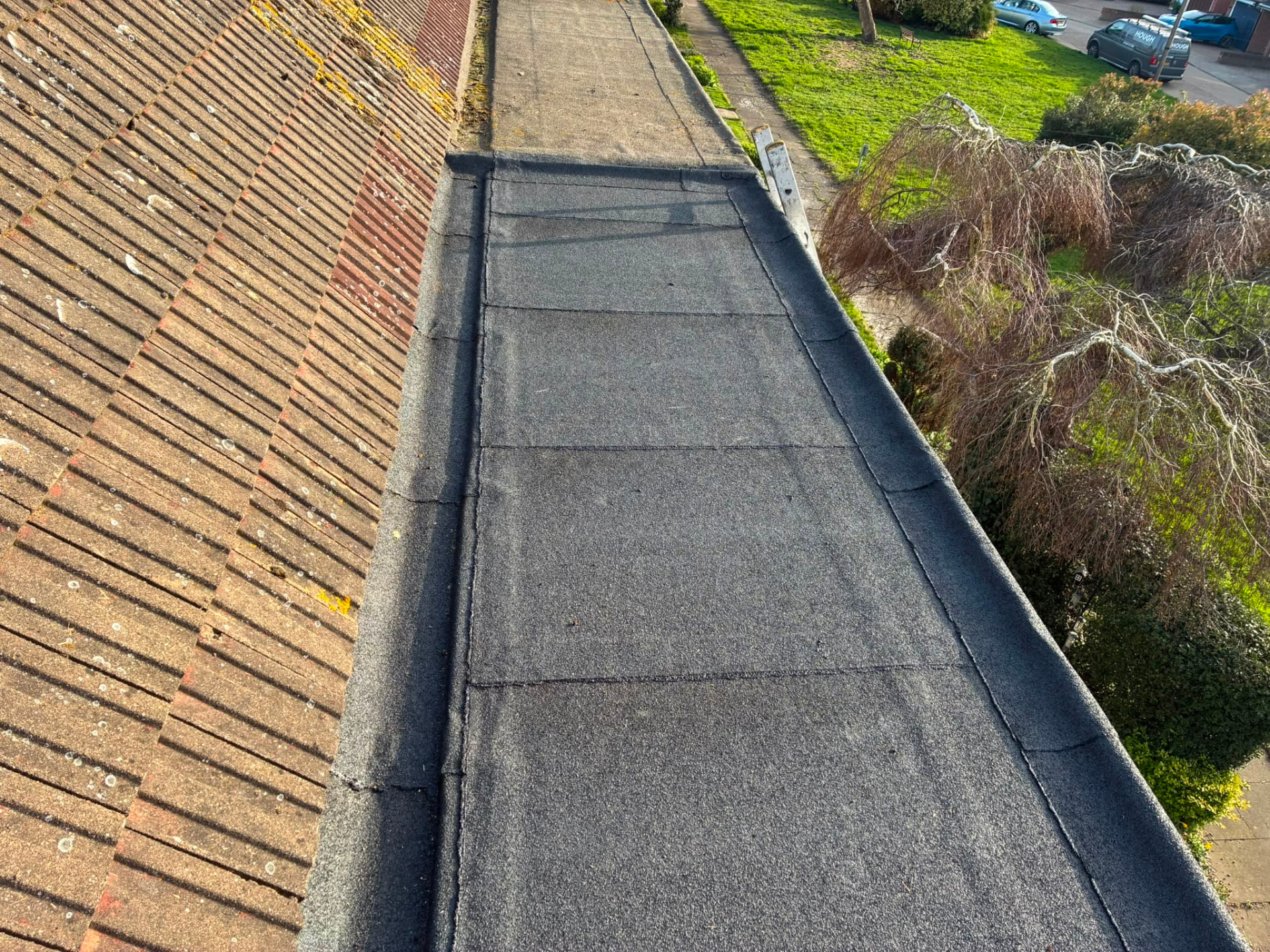New mineral felt flat roof meeting an existing tiled roof
